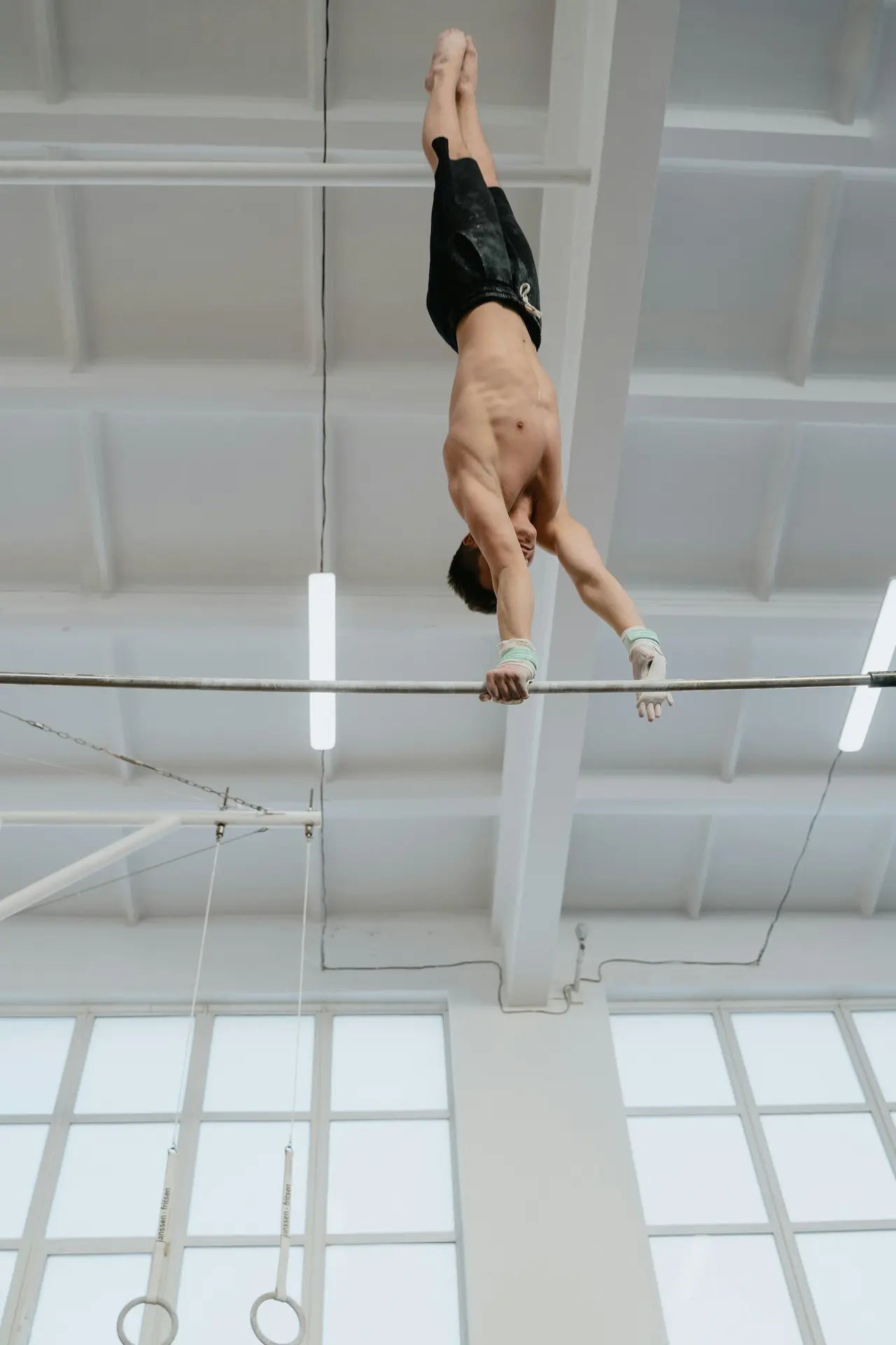 Turner am Reck im Handstand zur halben Drehung