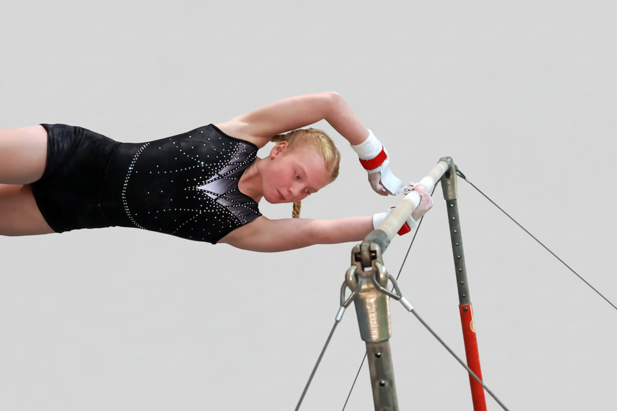 Turnerin am Stufenbarren mit Stufenbarrenriemchen